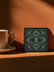 A black and emerald green ceramic coaster featuring a triple moon motif with celestial art deco sunbursts.